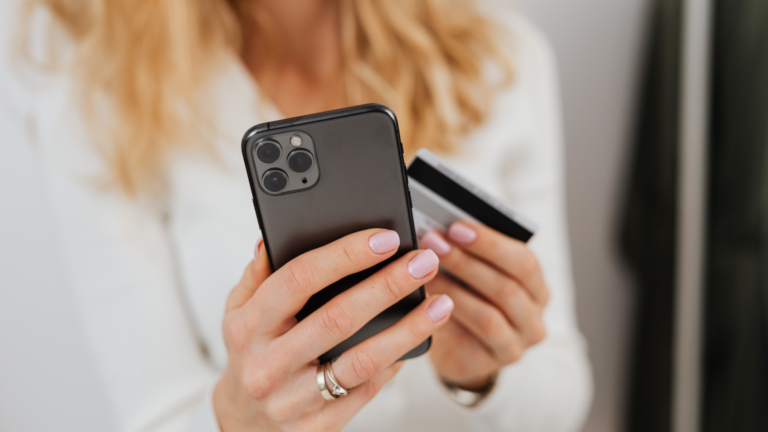 Kobieta sprawdza na telefonie stan swojego konta w banku